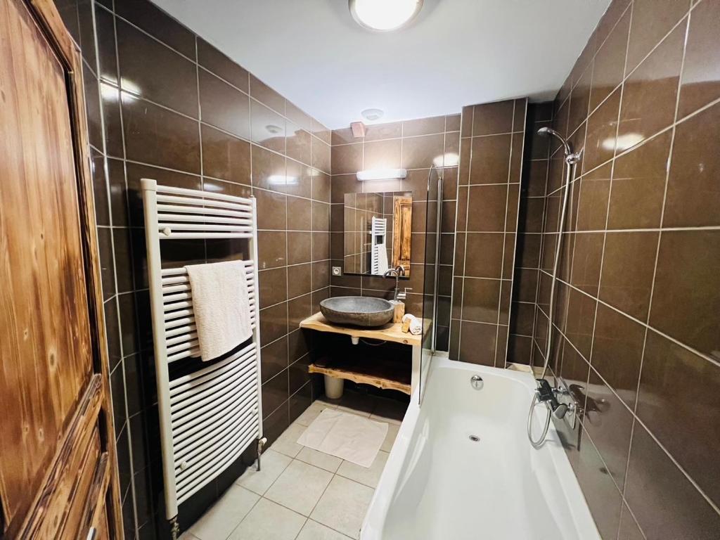 une salle de bain avec une baignoire et un lavabo dans l'établissement Nordique Symbiose, à Chapelle-des-Bois