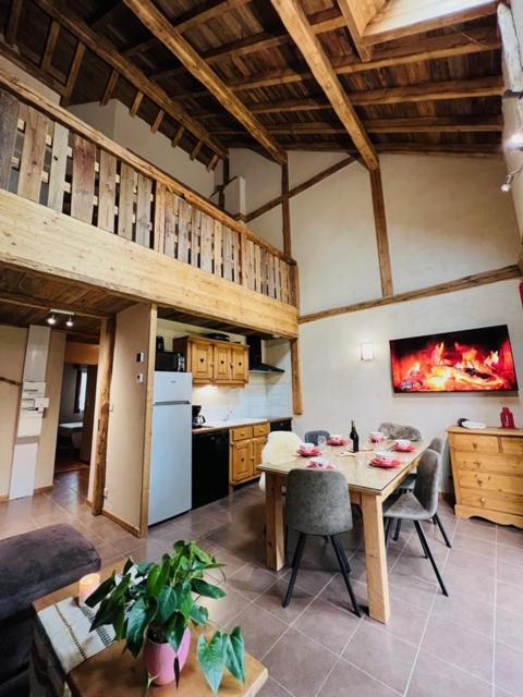 un salon avec une table et une cuisine dans l'établissement Nordique Symbiose, à Chapelle-des-Bois