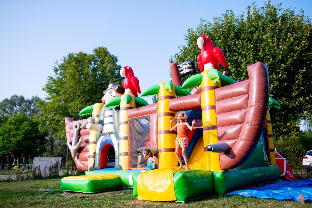une structure de jeu gonflable avec des enfants qui y jouent dans l'établissement Camping de Thoissey, à Thoissey