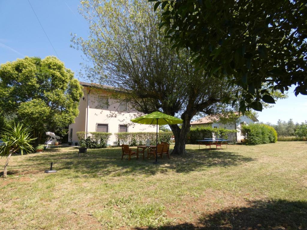 - une table et des chaises sous un parasol dans la cour dans l'établissement SCAPPO IN UMBRIA, Felicità 14a, à Giove