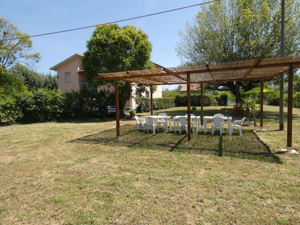 un groupe de tables et de chaises sous une pergola dans l'établissement SCAPPO IN UMBRIA, Felicità 14a, à Giove