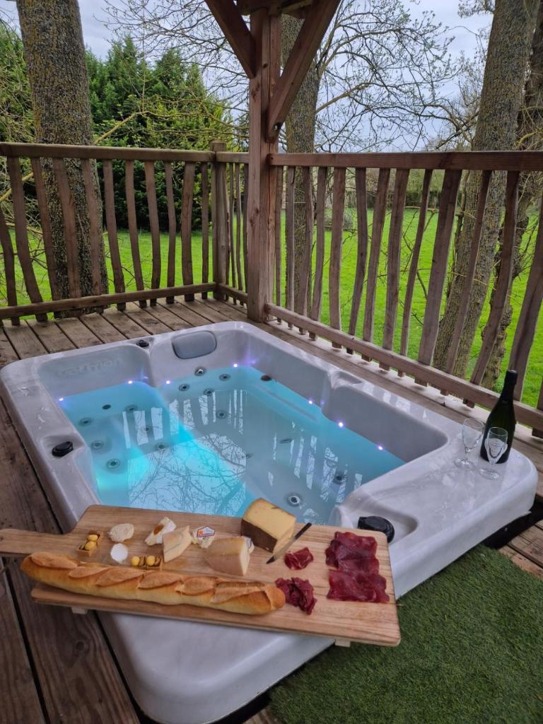 - un bain à remous sur une terrasse avec de la nourriture dans l'établissement Cabane insolite 2 p Jacuzzi Domaine du Marais 91 Magnolia, à Maisse