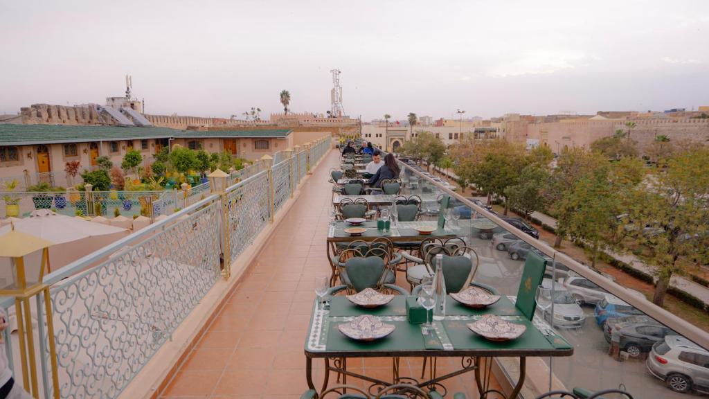 - un balcon avec des tables et des chaises dans un bâtiment dans l'établissement Riad Golden Mansour, à Meknès
