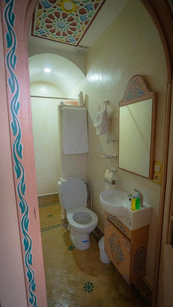 une salle de bain avec toilettes, lavabo et miroir dans l'établissement Riad Golden Mansour, à Meknès