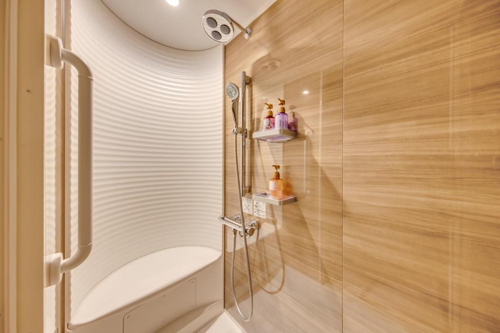 une salle de bain avec douche et toilettes dans l'établissement Inatori Ginsuiso, à Higashiizu