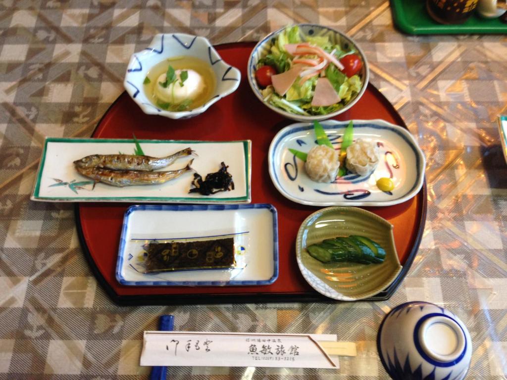 un groupe de plaques alimentaires sur une table dans l'établissement Uotoshi Ryokan, à Yamanouchi