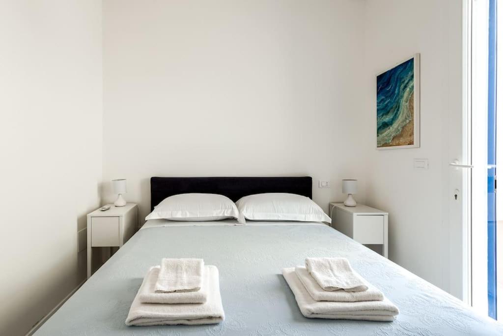 une chambre blanche avec un lit avec deux serviettes dessus dans l'établissement Marinaia - Casa Aurora, à Diso