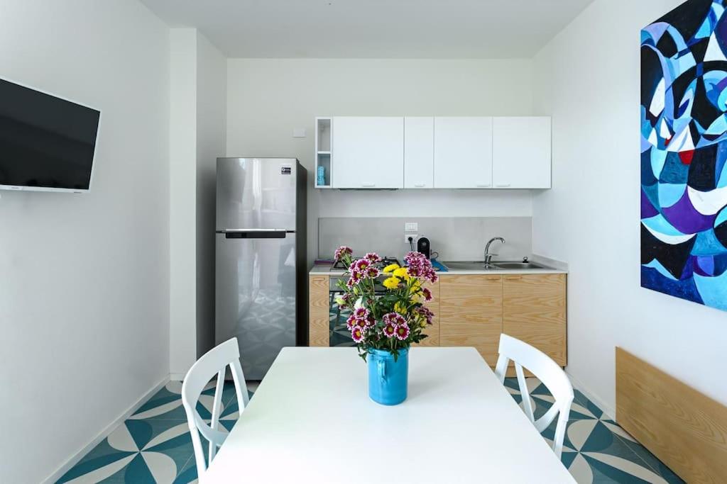 une cuisine avec une table avec un vase de fleurs dessus dans l'établissement Marinaia - Casa Aurora, à Diso