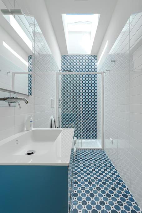 La salle de bains bleue et blanche est pourvue d'une douche et d'un lavabo. dans l'établissement Marinaia - Casa Aurora, à Diso
