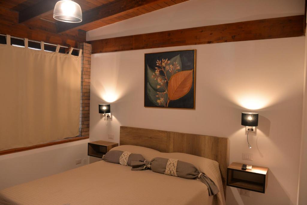une chambre avec un lit et un tableau au mur dans l'établissement Marlù Luxury Rooms Pool and Garden, à Aradeo