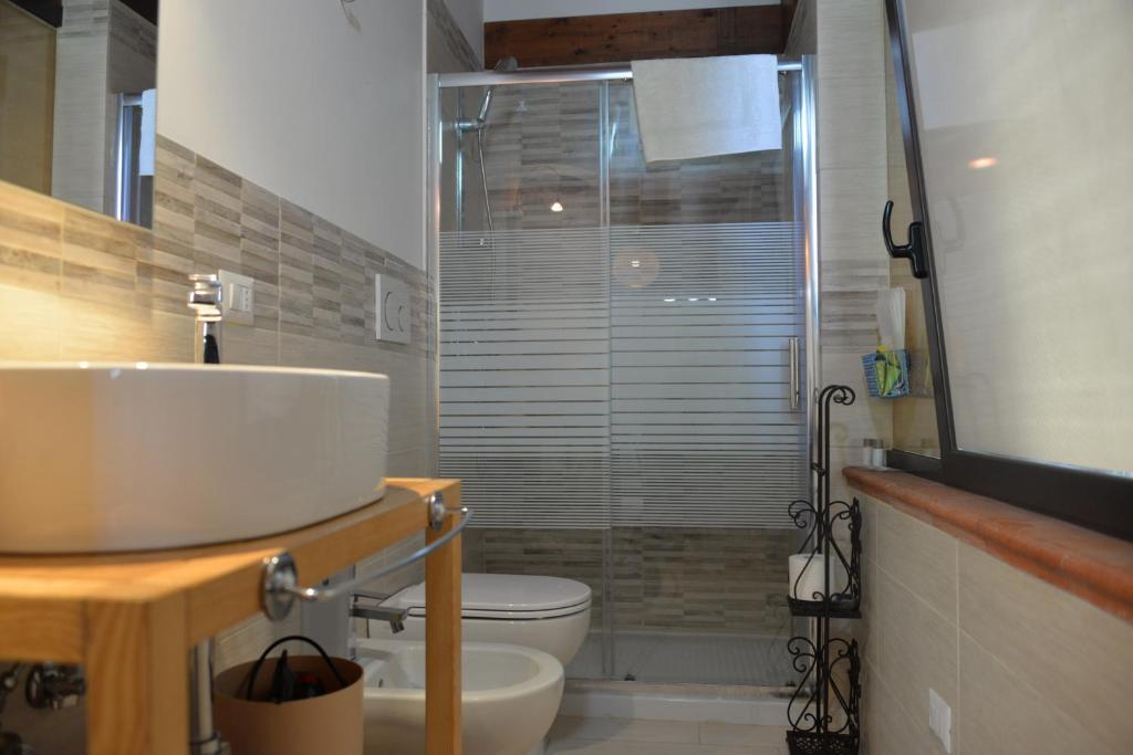 une salle de bain avec un lavabo, des toilettes et une douche dans l'établissement Marlù Luxury Rooms Pool and Garden, à Aradeo