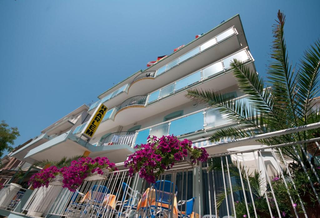 un bâtiment blanc avec des fleurs violettes devant dans l'établissement Hotel Haarlem, à Rimini