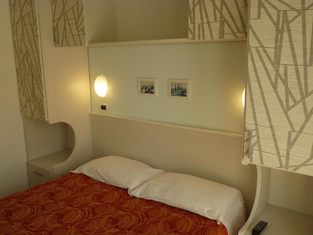 une petite pièce avec un lit et une fenêtre dans l'établissement Hotel Haarlem, à Rimini