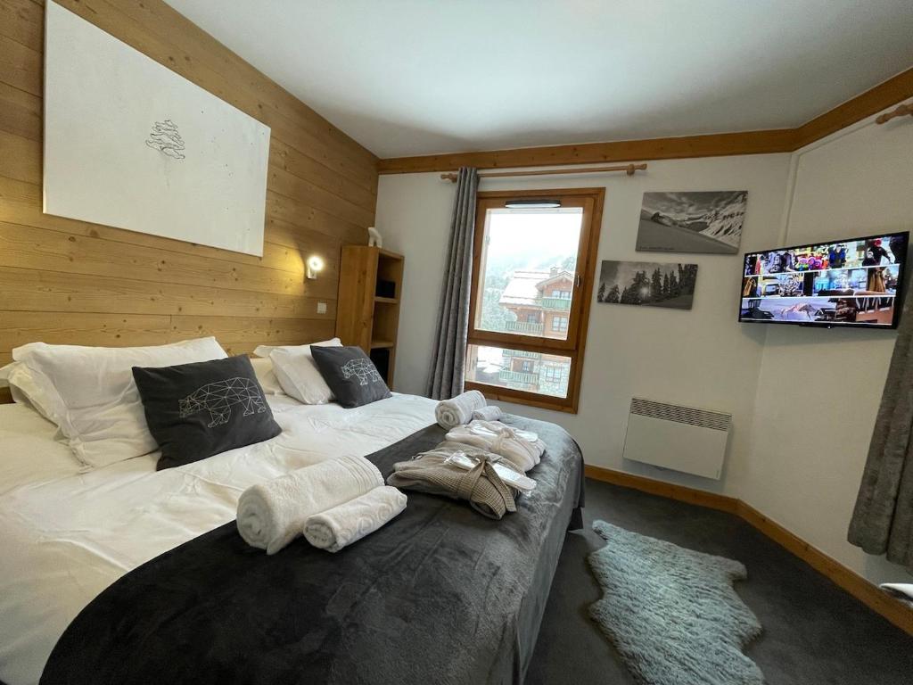 une chambre avec un lit avec des serviettes dessus dans l'établissement Arc 1950 - Appartement 2 chambres - Ski-in & out - Grande Terrasse Ensoleillée, à Arc 1950
