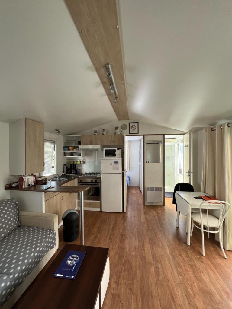 une cuisine et un salon avec un canapé et une table dans l'établissement Camping Del Mar 42, Mobile Home O'Hara, 2 chambres, 4 personnes, bord de mer, à Argelès-sur-Mer