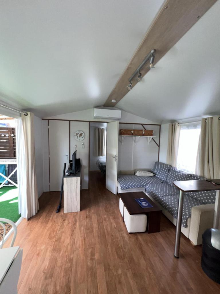 un salon avec un lit et une table dans l'établissement Camping Del Mar 42, Mobile Home O'Hara, 2 chambres, 4 personnes, bord de mer, à Argelès-sur-Mer