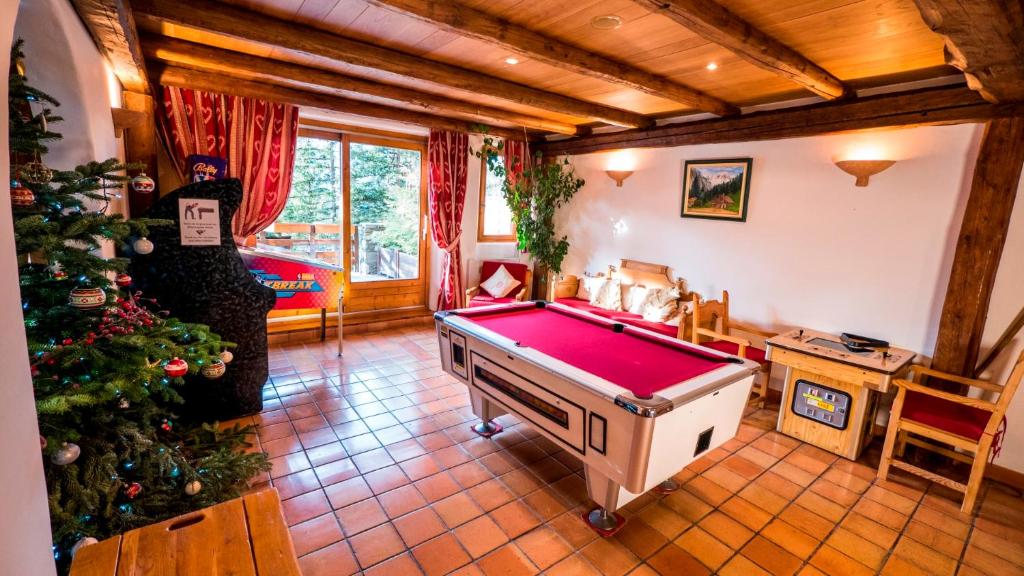 Cette chambre dispose d'un billard et d'un arbre de Noël. dans l'établissement Les Appartments du Merilys, à Méribel
