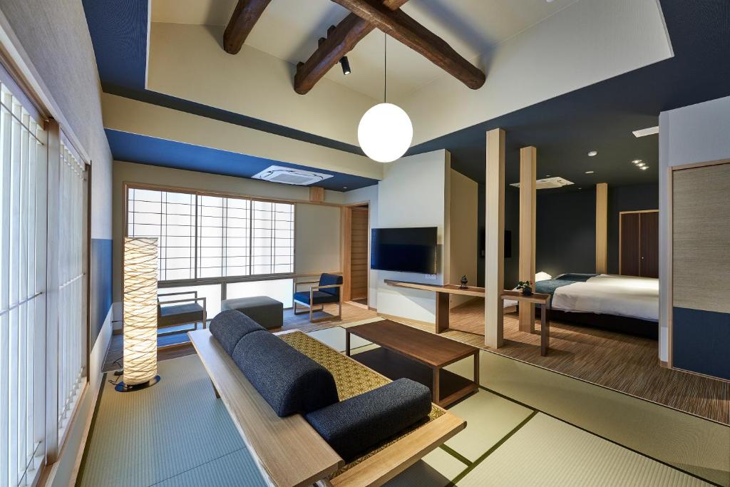 un salon avec un canapé et un lit dans l'établissement AKARI et KAORI formerly Taizanso, à Izu