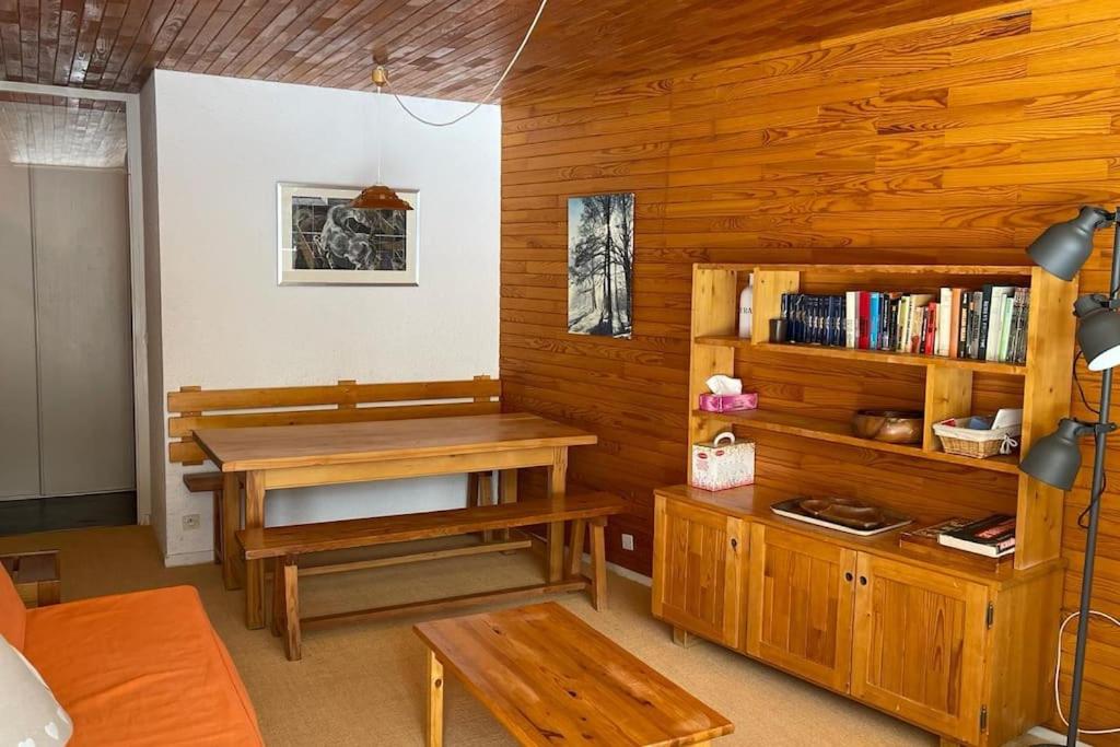 - un salon avec une table et une étagère dans l'établissement T3 aux Ecrins IV, skis aux pieds à Vars, à Vars