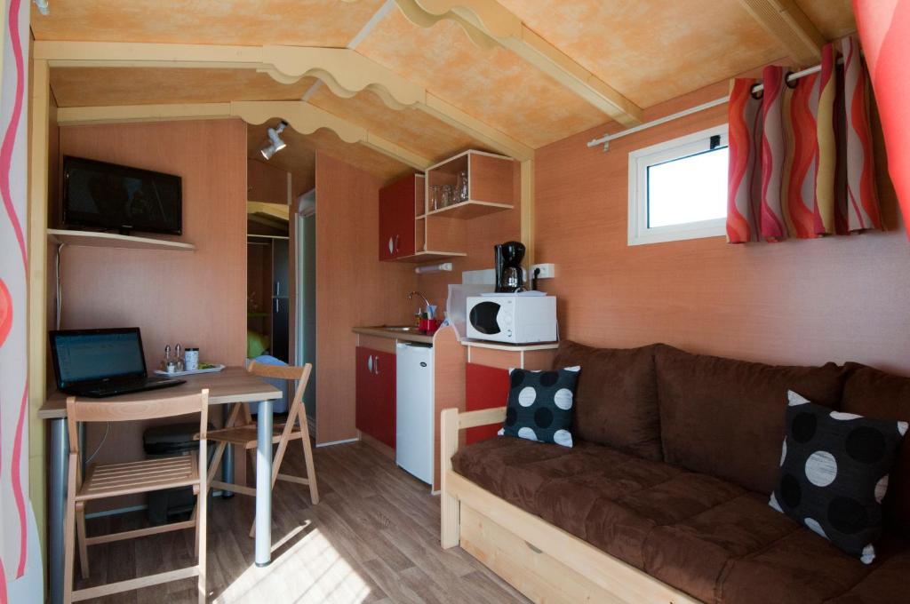 un salon et une cuisine avec un canapé et une table dans l'établissement Nuits Insolites d Argonne, à Varimont