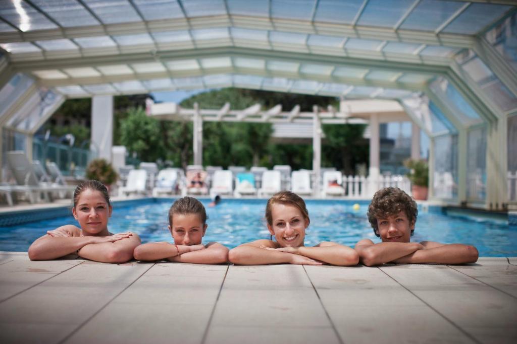 Trois enfants se reposent dans une piscine dans l'établissement B&B Isabella, à Milano Marittima