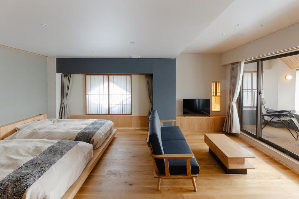 une chambre avec un lit, un canapé et une télévision dans l'établissement onogawaonsen azumasou, à Yonezawa