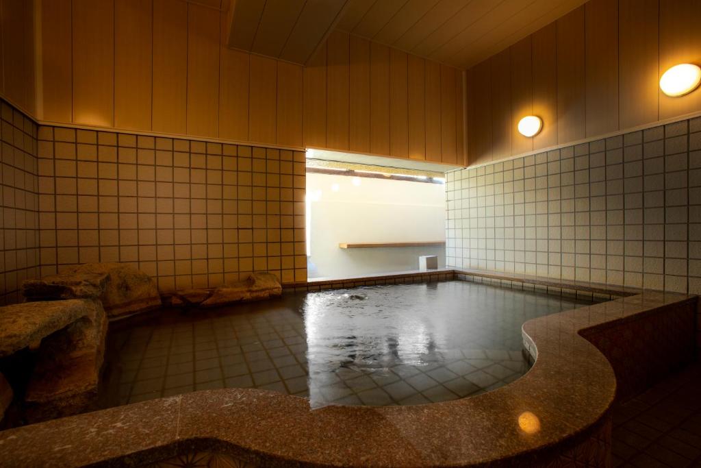Cette chambre est dotée de carrelage et d'une piscine. dans l'établissement まち宿 壱龍 MACHIYADO ICHIRYU, à Takayama