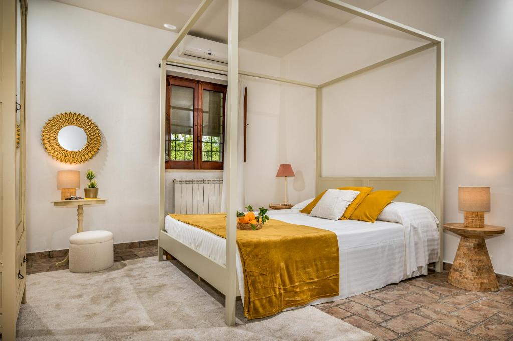 une chambre avec un lit à baldaquin dans l'établissement Il Giardino Dei Limoni 8, Emma Villas, à Ispica