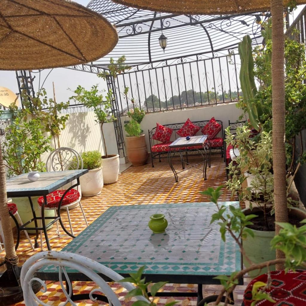 une terrasse avec une table et des chaises dans une serre. dans l'établissement Dar "JENNA-ROSE", à Marrakech