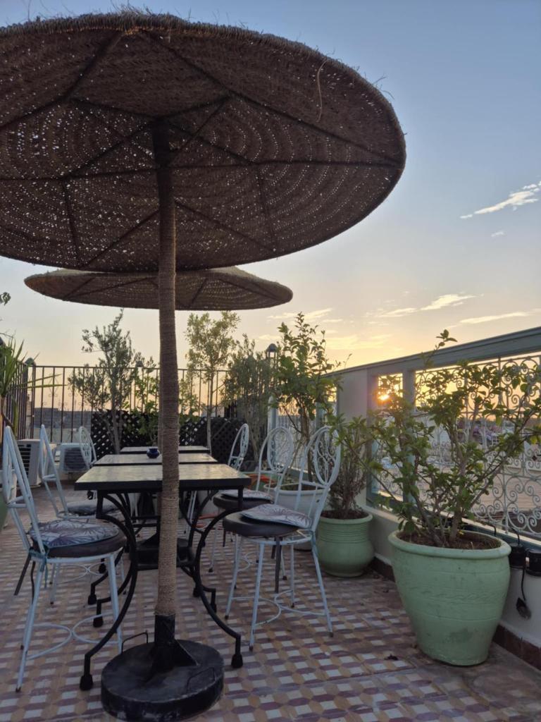 - une table et des chaises sous un parasol sur la terrasse dans l'établissement Dar "JENNA-ROSE", à Marrakech 37 autres photos
