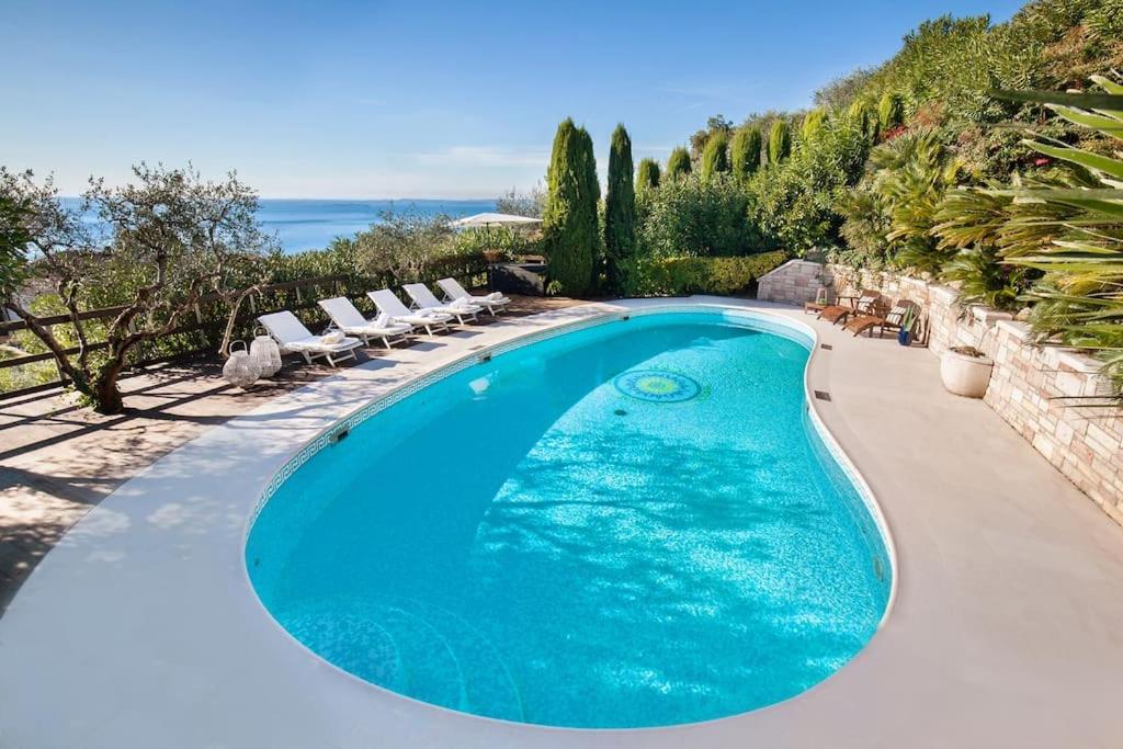 une piscine avec des chaises longues et une piscine dans l'établissement Villa Rosa del Garda Golf and Bike, à Garde