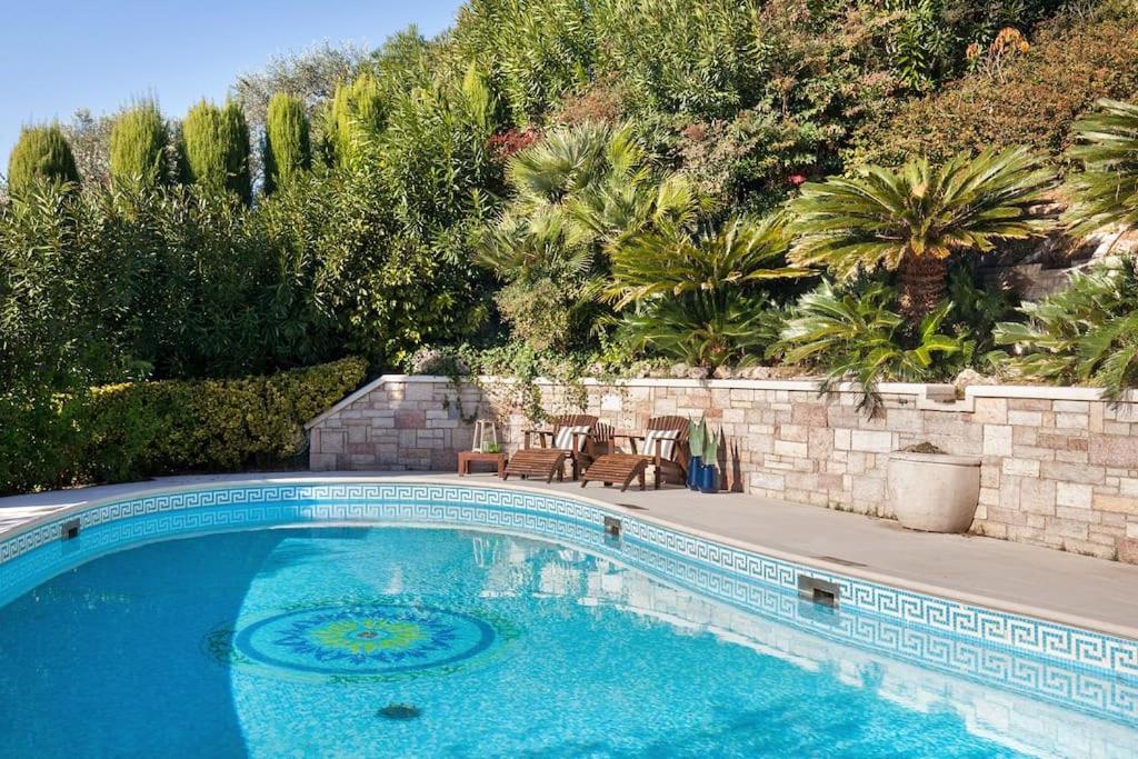 - une piscine avec 2 chaises à côté d'un mur dans l'établissement Villa Rosa del Garda Golf and Bike, à Garde