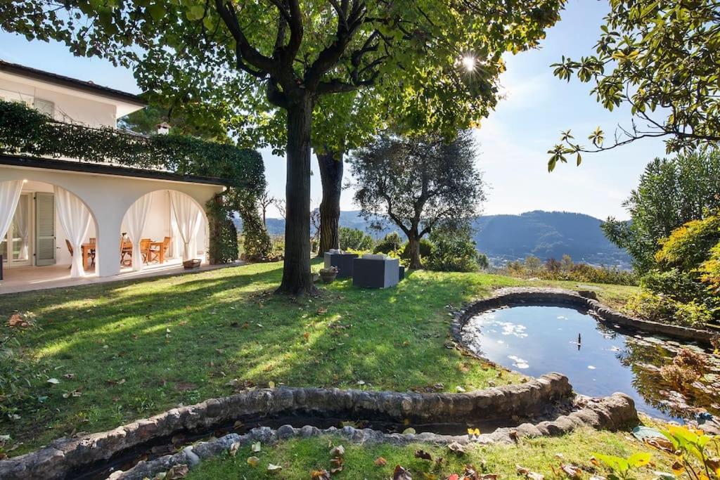 une maison avec un étang dans la cour dans l'établissement Villa Rosa del Garda Golf and Bike, à Garde