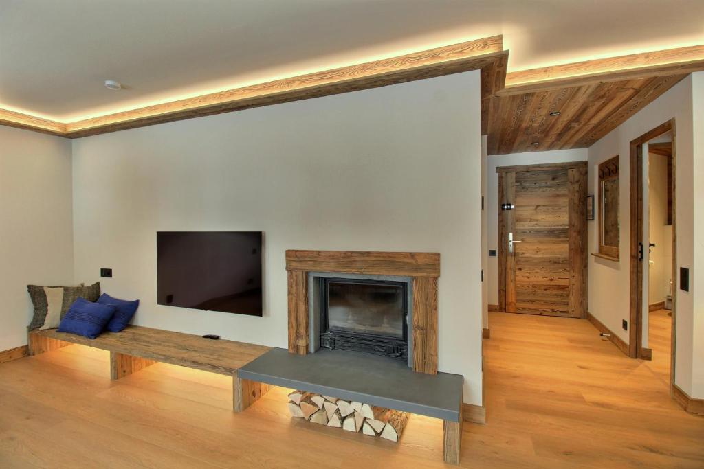 un salon avec une cheminée et une télévision dans l'établissement ARC 1950 - Appartement 8 personnes Duplex Cheminée - ski aux pieds - Sauna, Hammam, Jacuzzi, Piscine, à Arc 1950