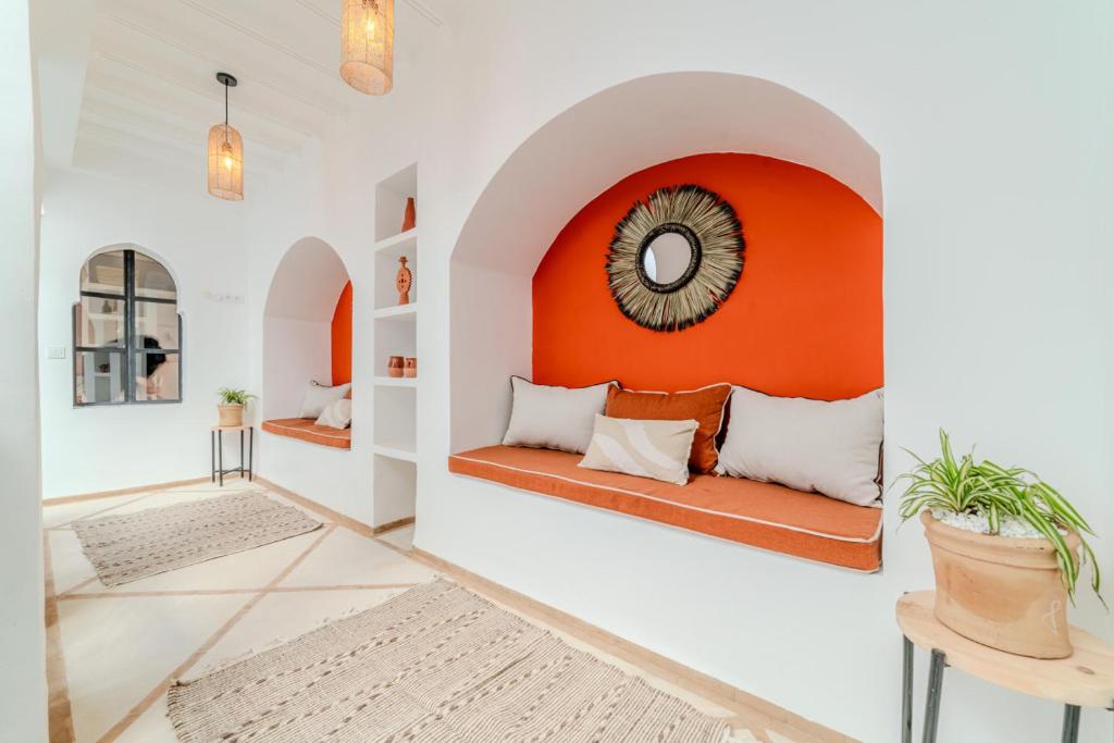- un salon blanc et orange avec un canapé dans l'établissement Riad Zemzem Au Coeur de la medina Petit dejeuner, à Marrakech