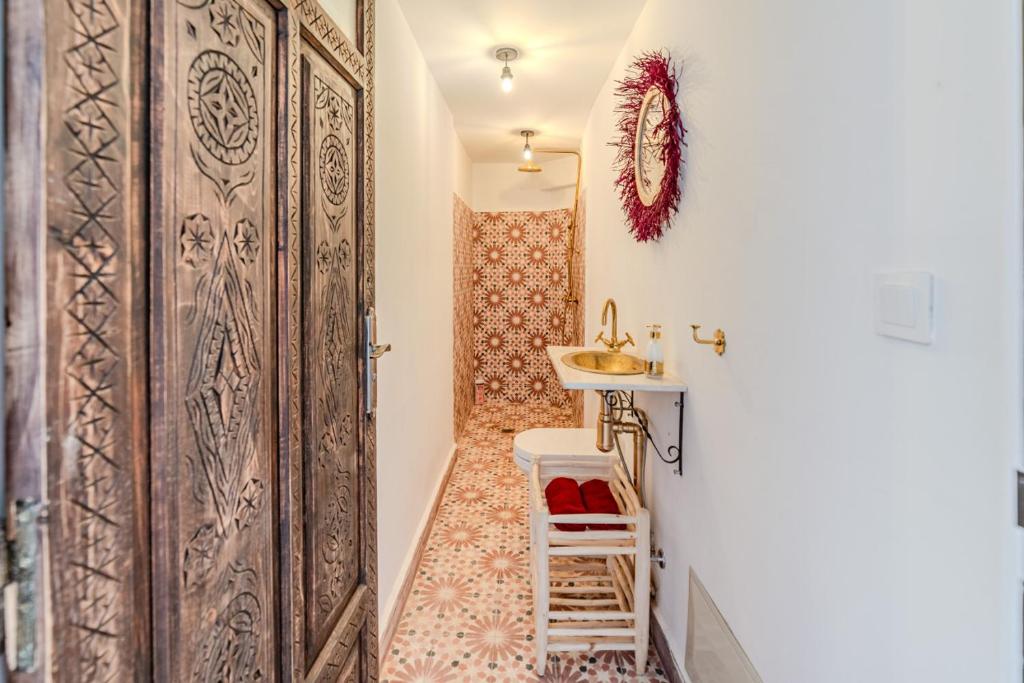 d'une petite salle de bains avec un lavabo et une porte. dans l'établissement Riad Zemzem Au Coeur de la medina Petit dejeuner, à Marrakech