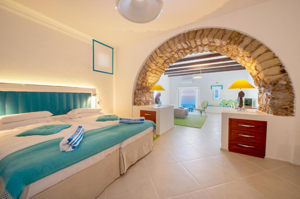 une chambre avec un grand lit et une arcade dans l'établissement Piccolo Grand Hotel, à Pizzo