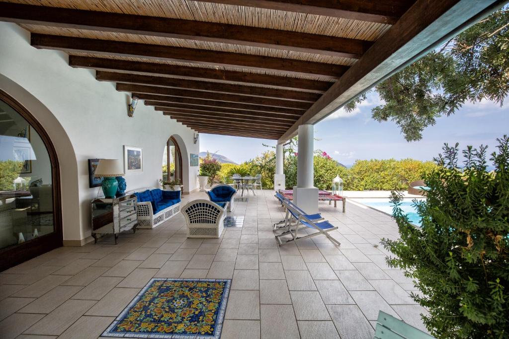 un patio extérieur avec des chaises et une piscine dans l'établissement Sealight Villa Lipari - Vista e Piscina, à Lipari