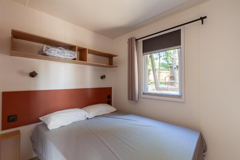 une chambre avec un lit et une fenêtre dans l'établissement MOBIL HOME Neuf FRONT DE MER TOUT CONFORT 5 LITS 6 personnes CARRY LE ROUET, à Carry-le-Rouet 37 autres photos
