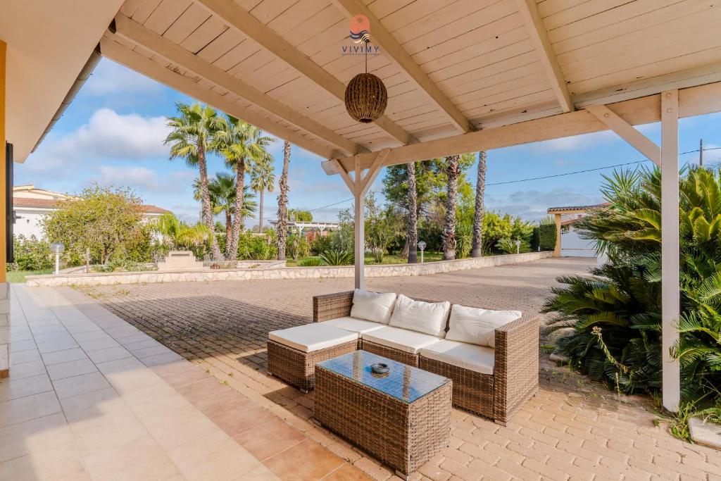 une terrasse avec un canapé et une table dans l'établissement Villa Diletta by Vivimy, à Casarano