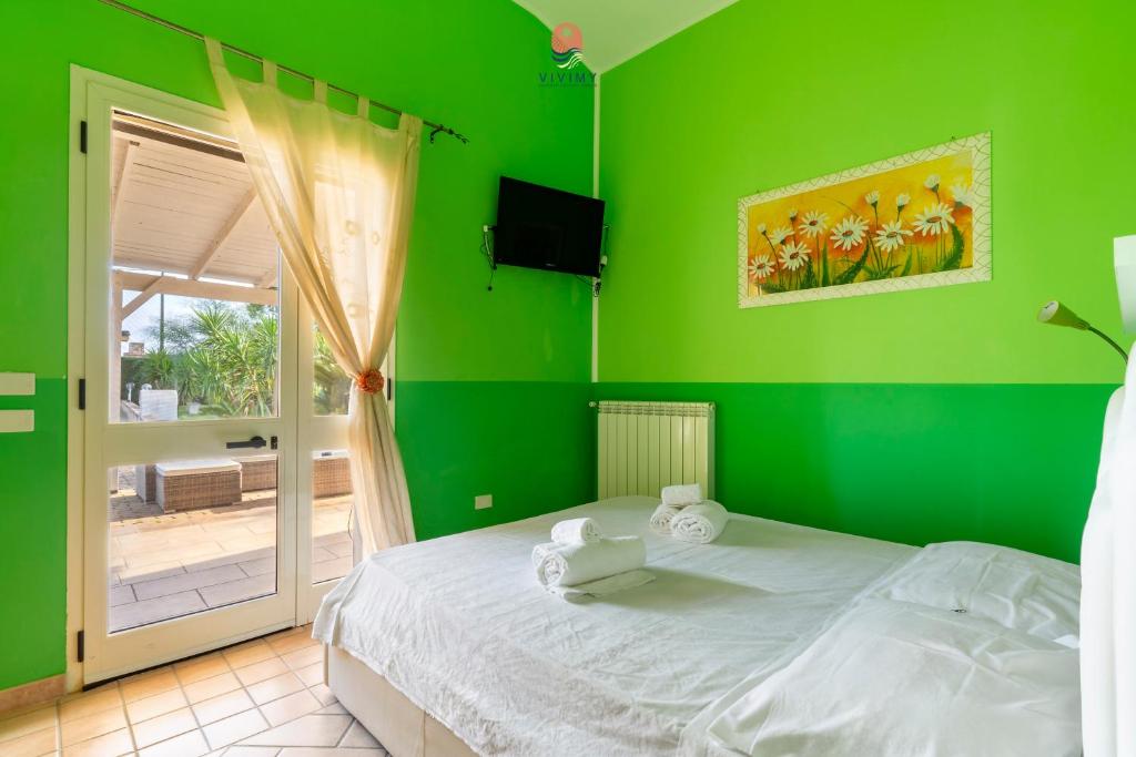 - une chambre verte avec un lit et une porte coulissante en verre dans l'établissement Villa Diletta by Vivimy, à Casarano 42 autres photos