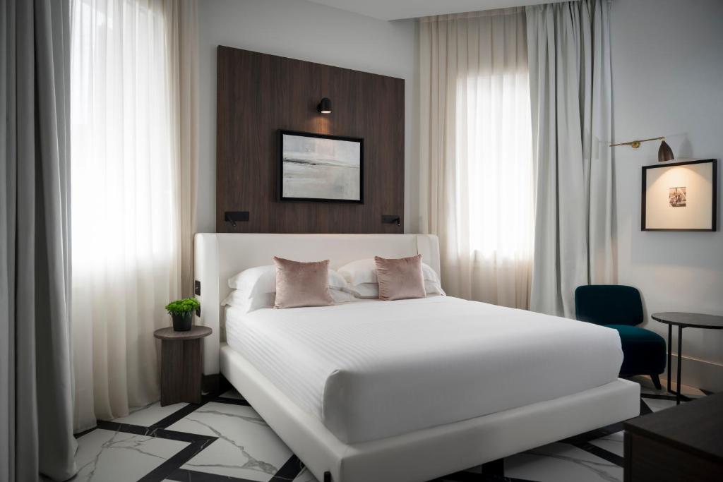 - une chambre avec un grand lit blanc et des rideaux dans l'établissement Casa Riva, à Riccione