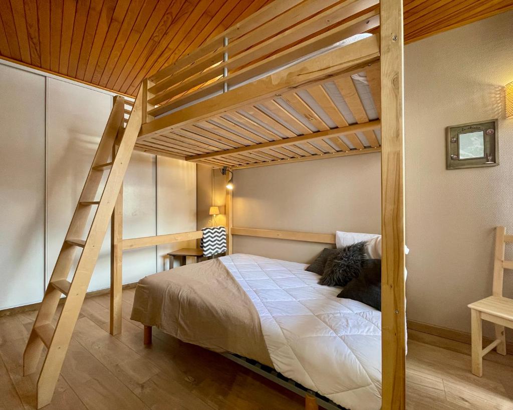- une chambre avec des lits superposés en bois et une échelle dans l'établissement Homency - Résidence de l'Oisans C0, à L'Alpe-d'Huez