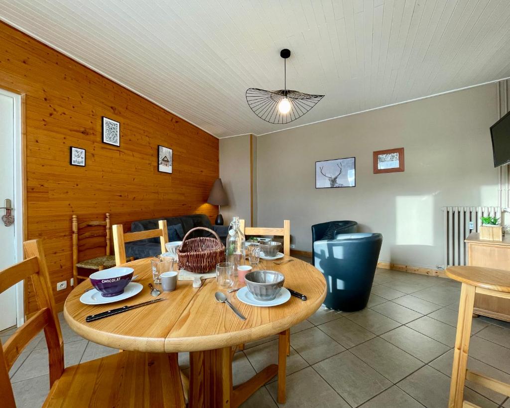 une salle à manger avec une table et des chaises en bois dans l'établissement Homency - Résidence de l'Oisans C0, à L'Alpe-d'Huez