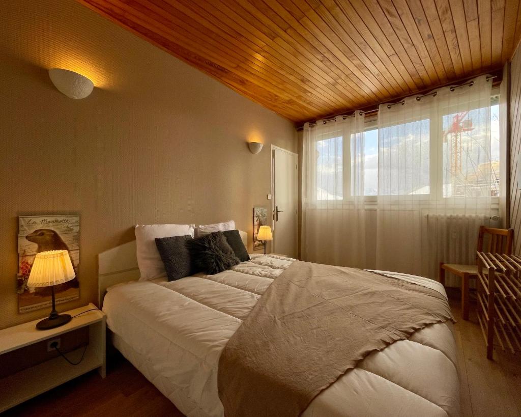 une chambre avec un grand lit et une fenêtre dans l'établissement Homency - Résidence de l'Oisans C0, à L'Alpe-d'Huez