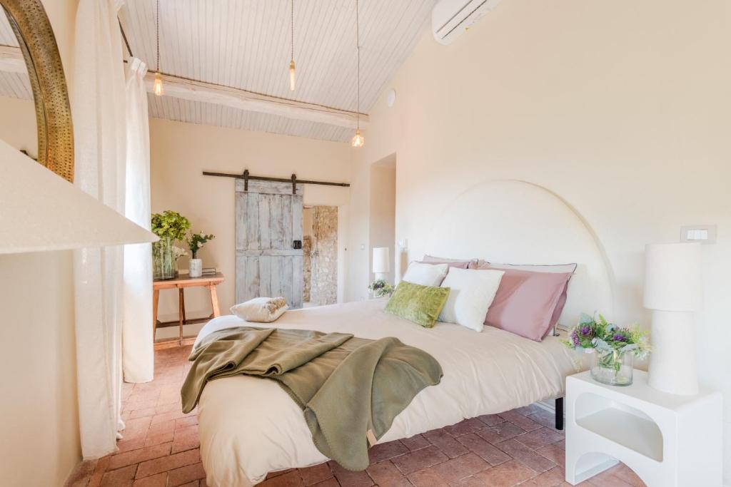 - une chambre dotée d'un grand lit avec des oreillers roses et verts dans l'établissement Le Due Terre Farmhouse, à Monsummano