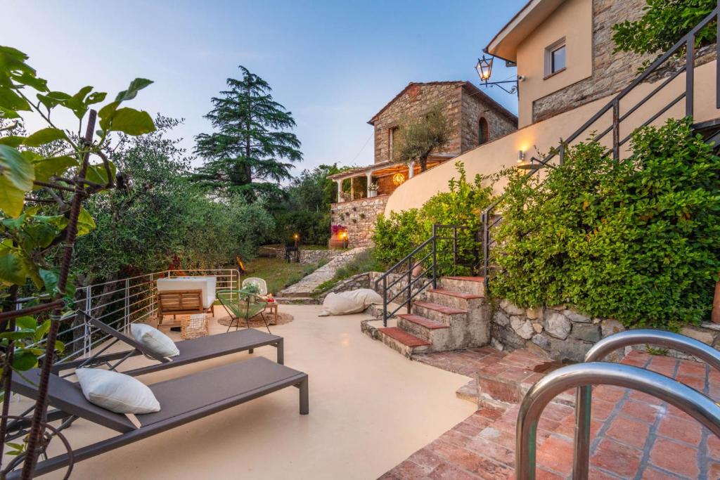 un patio avec deux bancs et un bâtiment dans l'établissement Le Due Terre Farmhouse, à Monsummano