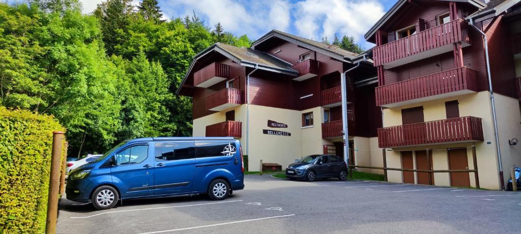 une camionnette bleue garée dans un parking à côté d'un bâtiment dans l'établissement Appartement T2 à BERNEX avec WiFi, vue sur montagne, à Bernex