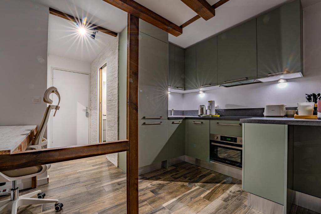 Il comprend une cuisine avec des placards verts et du parquet. dans l'établissement Ski in-out, Heart Val Thorens, Charming Studio, Wifi 141, à Val Thorens 9 autres photos