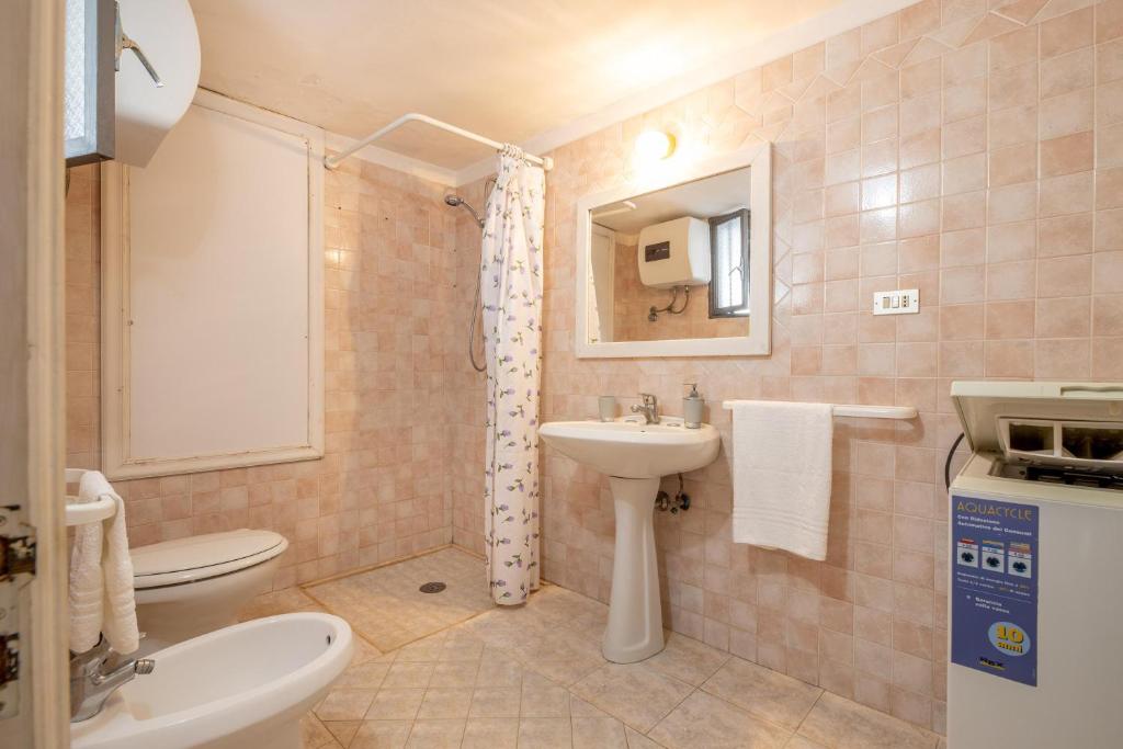 une salle de bain avec un lavabo, des toilettes et un miroir dans l'établissement Sun Beach Villa, à Marina di Mancaversa 26 autres photos